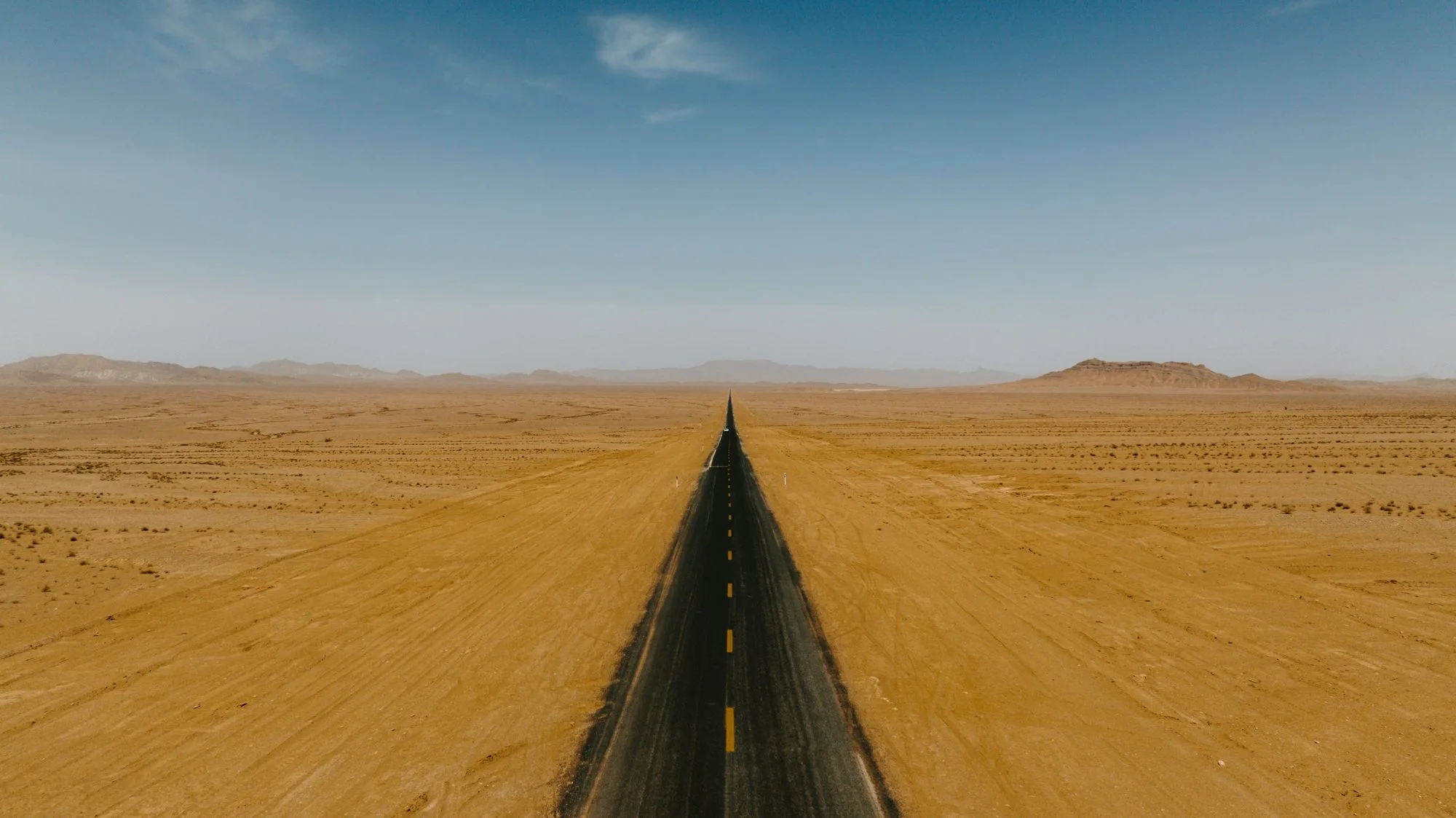 طريق مستقيم يعبر أرضًا صحراوية مفتوحة